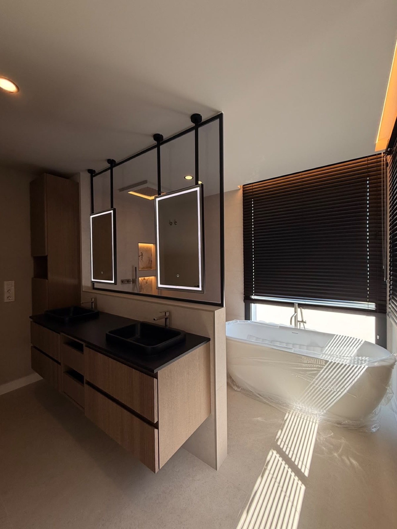 Baño principal reformado con bañera exenta, mampara de vidrio y luz natural.